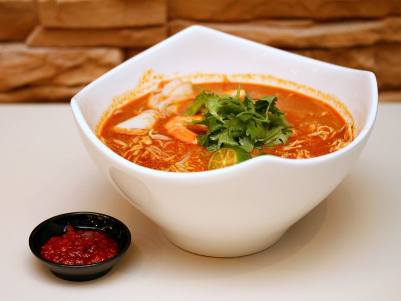 Фирменный сингапурский вид перанаканского блюда лакса - это лакса катонг